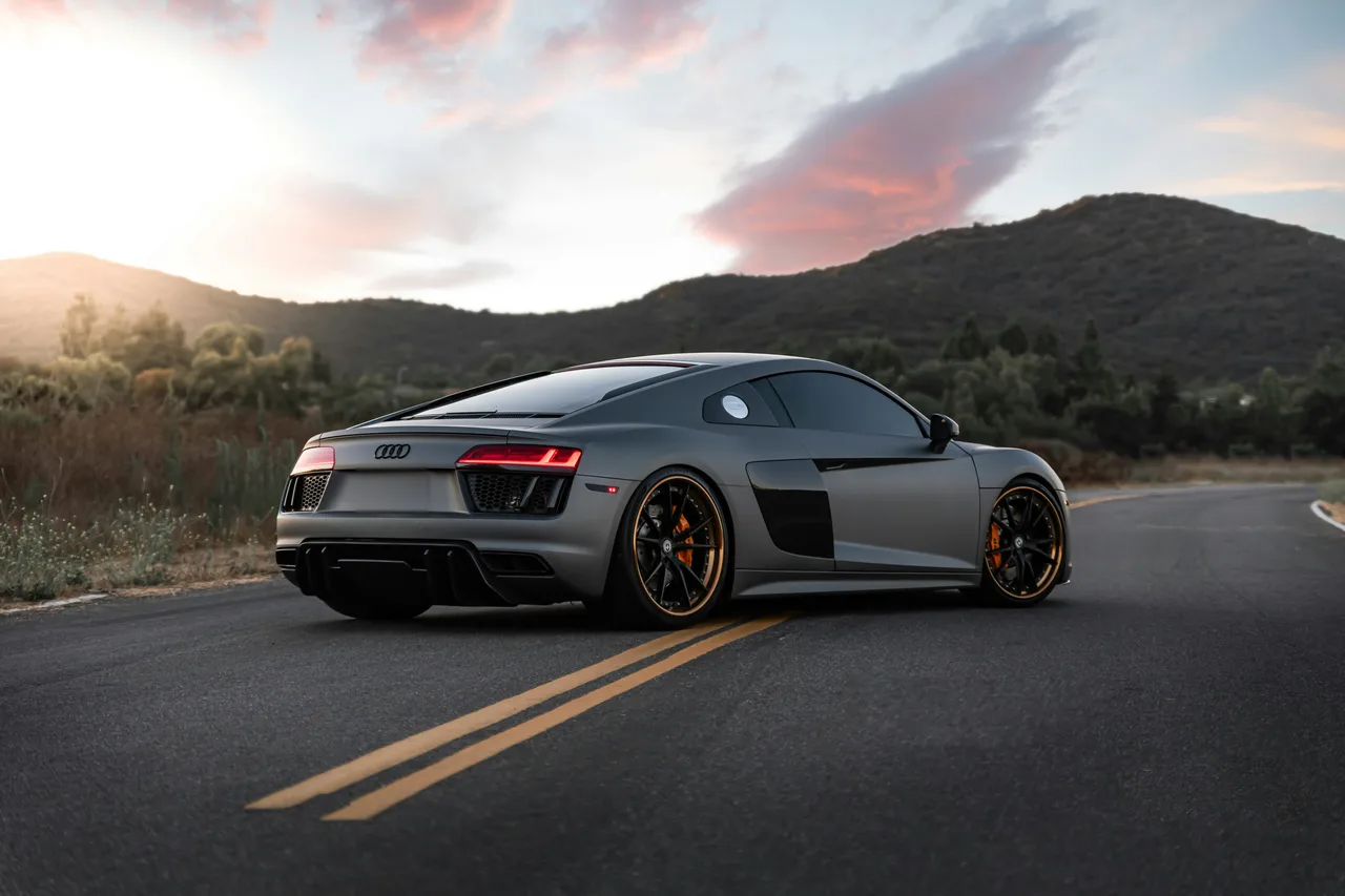 Grey Audi R8 on a hill road at sunset
