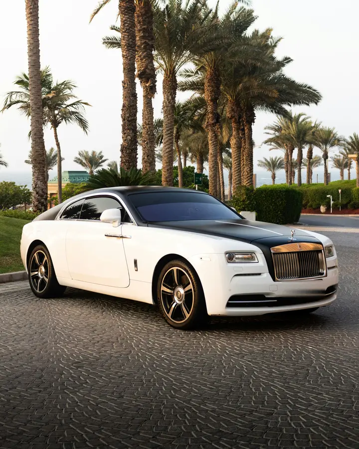 White Rolls-Royce Wraith on a palm-lined drive